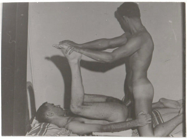Two guys form a sculptural composition as the top looks away vintage gay erotic photo