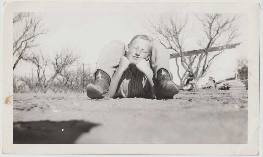 Vintage snapshot worm's eye view of two guys lying in the dirt forming a single, very strange creature.