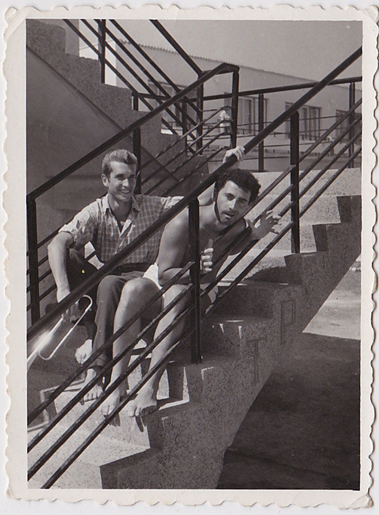 Anonymous vintage snapshot of two handsome guys sitting on a staircase