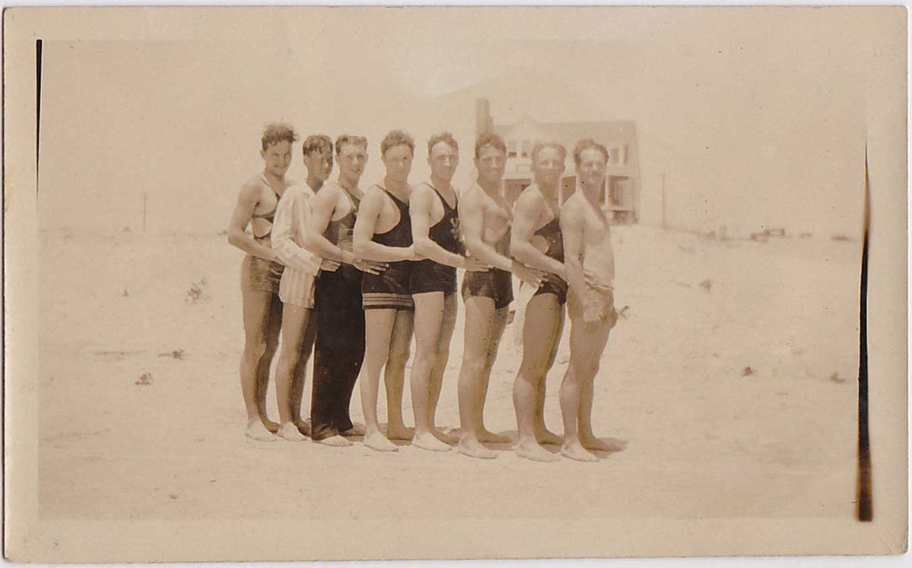 vintage photo Eight guys stand in a row with hands on hips of the guy in front.