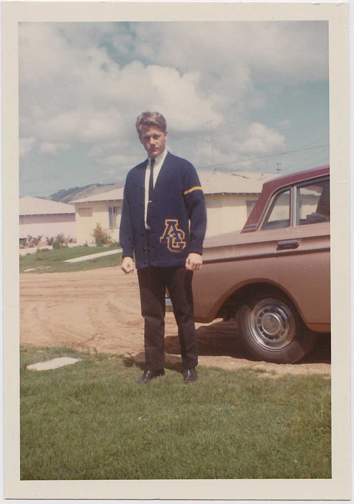 vintage color snapshot of a handsome blond jock standing by a car 