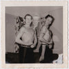 Two shirtless young guys flexing in the living room; double exposure gay snapshot