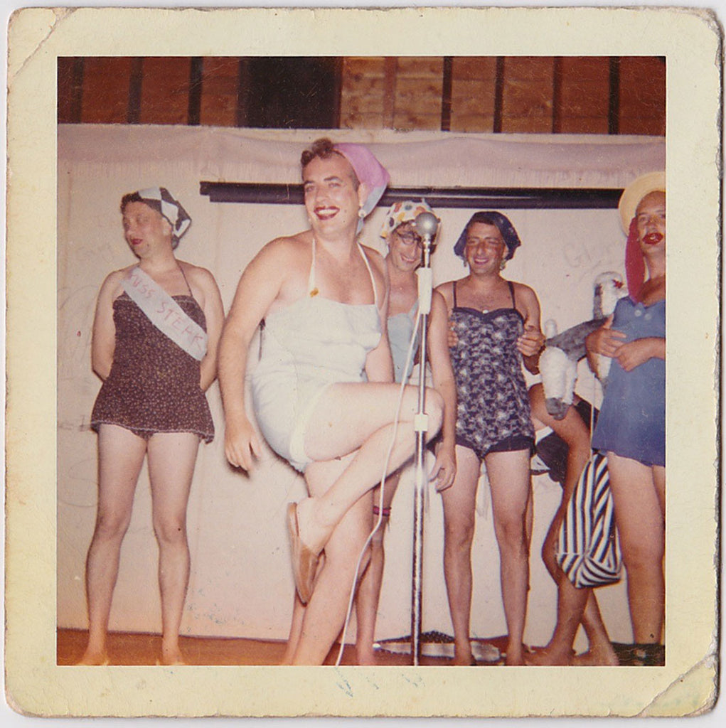 Bunch of guys who seem to be enjoying their girlie moment on stage. The contestant on the left wears a "Miss Steak" ribbon. 