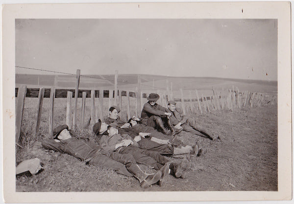 happy soldiers recline along fence vintage snapshot 1930s