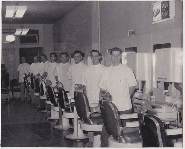 Vintage snapshot Eight young barbers stand by their chairs.