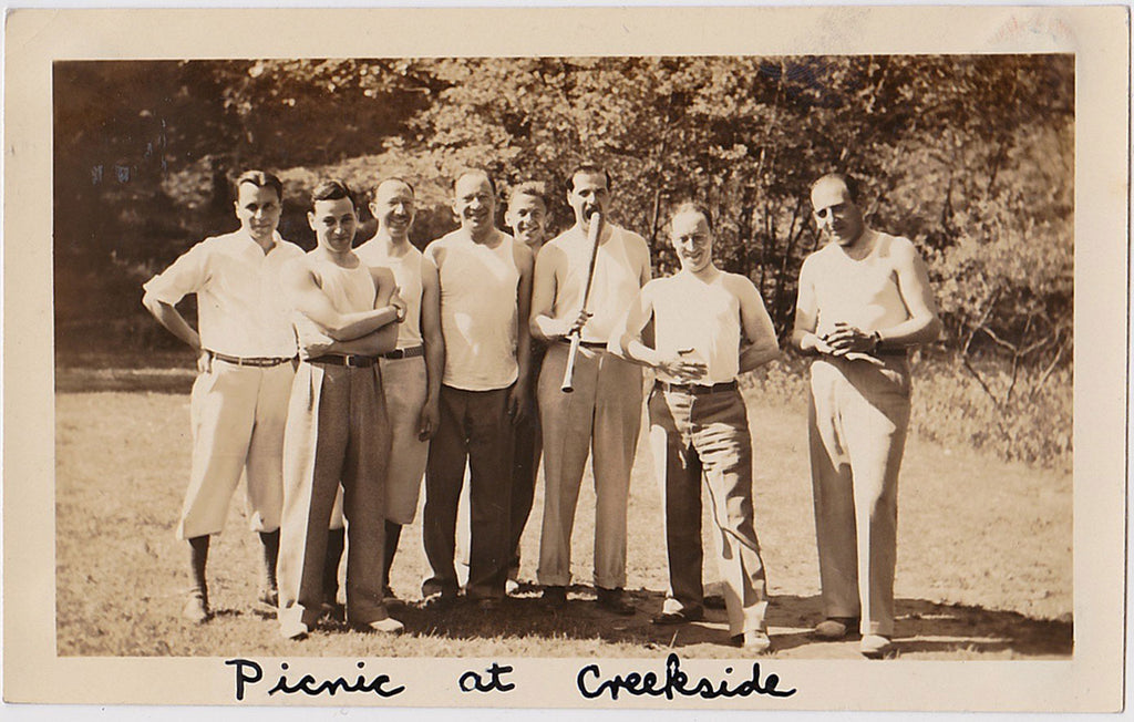 Eight guys pose for a photo while on a picnic vintage sepia snapshot