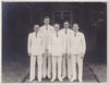 Five dapper gents in white suits with double-breasted jackets and a boutonniere, vintage snapshot
