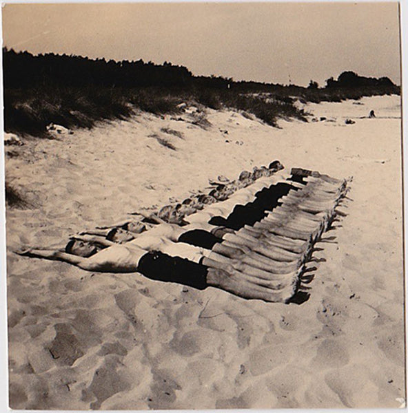 Amazing snapshot of a very long row of guys lying on the sand