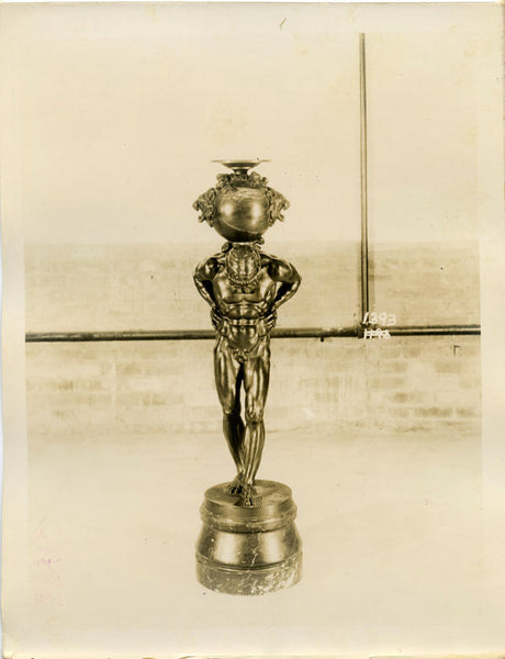 Elegant bronze figure of Atlas on a marble base, with brick wall and plumbing in the background. Item number 1393.  Vintage sepia photo