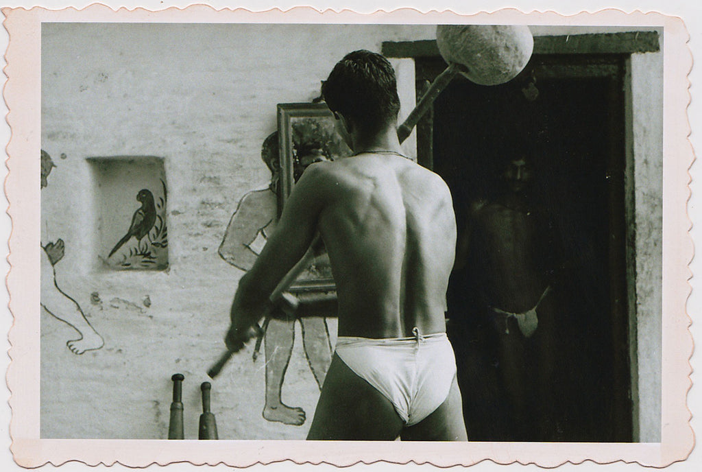 Beautiful vintage photo of a young Indian wrestler training with an exercise gada