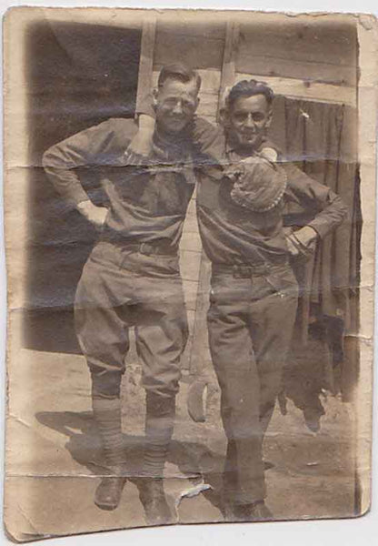 Two handsome soldiers take time out from the game to pose with arms around each other's shoulders. vintage photoh