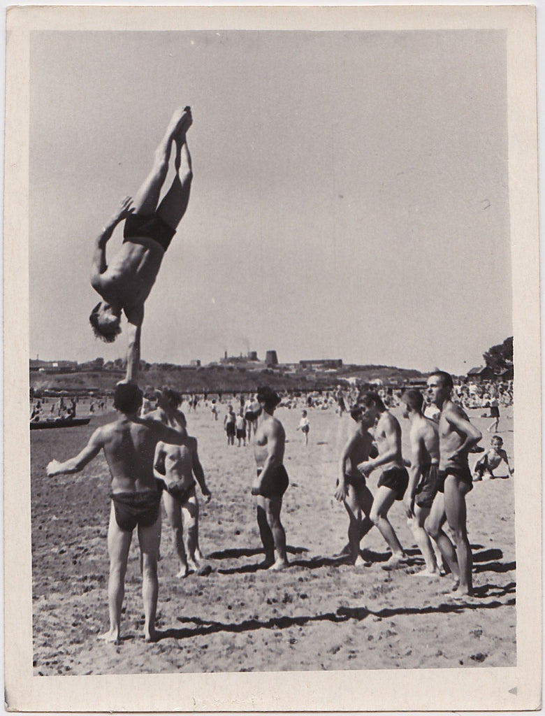 A group of gymnasts have fun on the beach.    Vintage photo gloss finish, undated c. 1960s.
