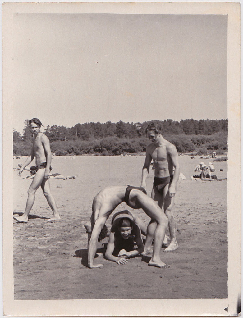 Three muscular gymnasts have fun on the beach  Vintage photo gloss finish, undated c. 1960s.