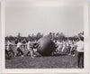 Men Pushing a Giant Leather Ball
