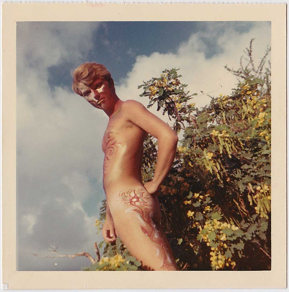 Vintage photo Handsome blond man displays the elaborate body paint which extends from his face down to his chest, butt and legs. 