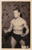 Handsome athlete poses in front of some exceptional wallpaper. Vintage real photo postcard