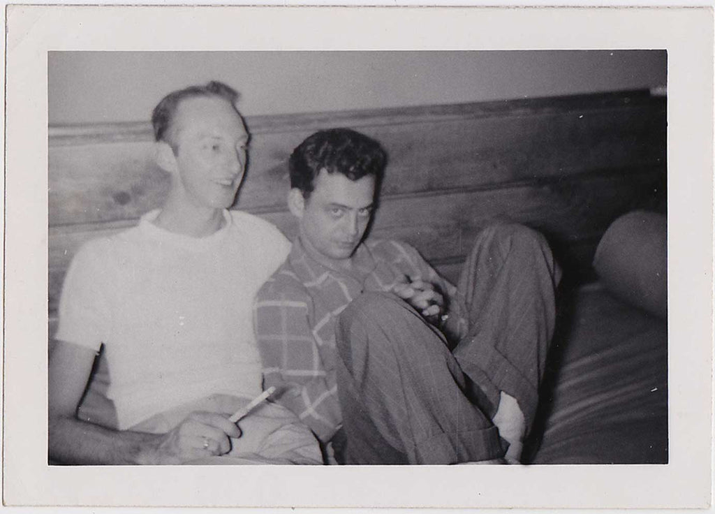vintage gay photo Two affectionate guys sit together on a bed.