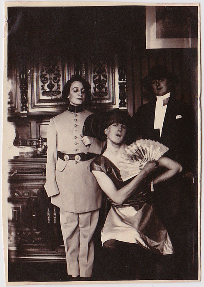 Rare and dramatic photos of what appears to be two women dressed as men and one man dressed as a woman.