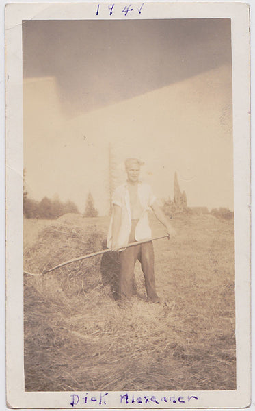 Vintage snapshot "Dick Alexander" stands with his white shirt open, sleeves rolled up, and pitchfork in hand