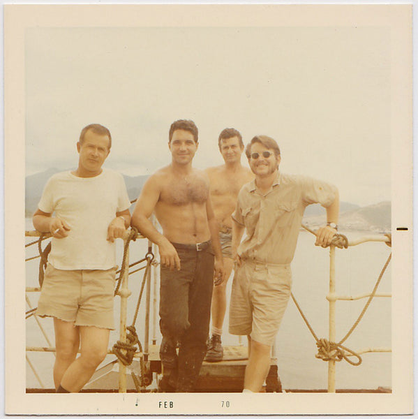 Four good-looking guys standing on a boat vintage color photo