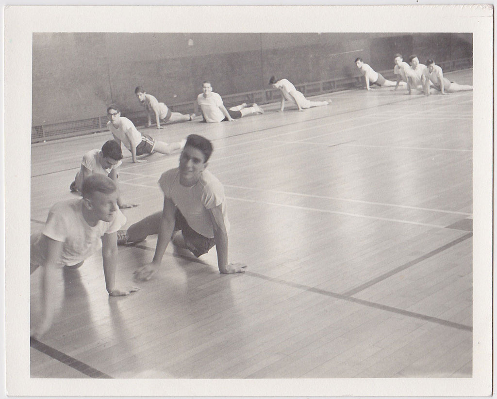 young guys stretching on the wood floor of the gym vintage photo