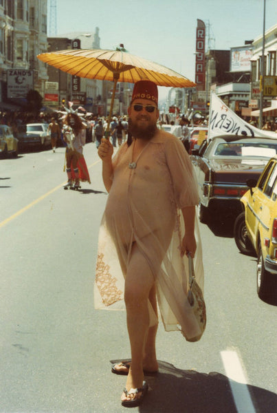 vintage color photo Chubby bearded guy holding an umbrella and posing in a diaphanous gown