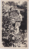 Anonymous vintage snapshot of a smiling naked man heading into the shrubbery
