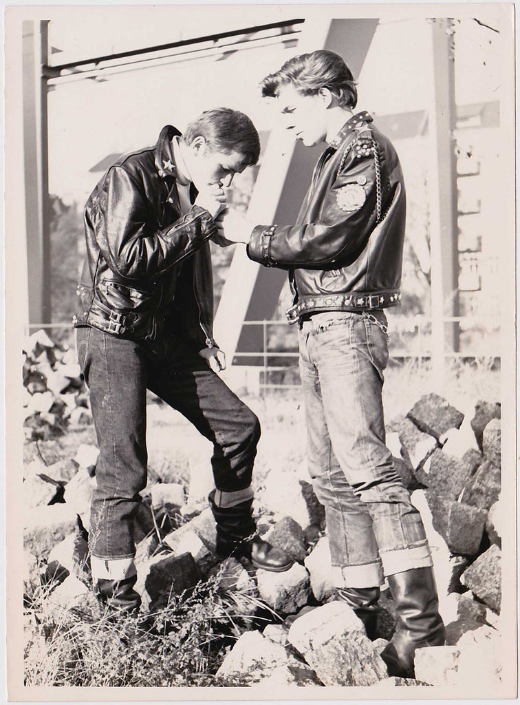 Two young leather guys sharing a smoke amid the rubble of post-war Berlin.  Vintage Gay photo 1950s