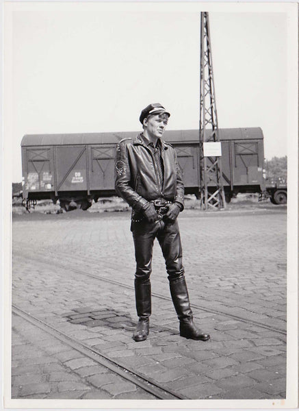 Man in full leather poses in front of a boxcar vintage photo German 1950s