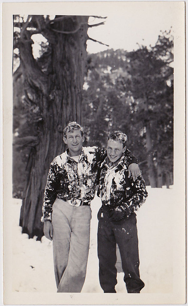 Two affectionate guys covered in snow. Vintage photo,