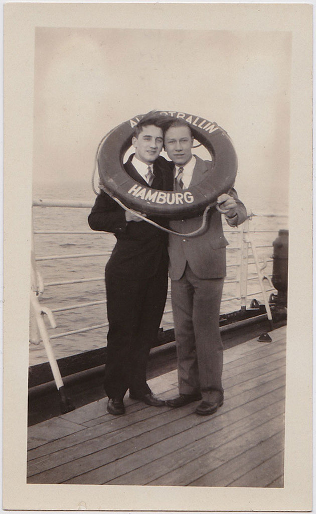 vintage snapshot Two men share a life preserver on the deck of a ship out of Hamburg.