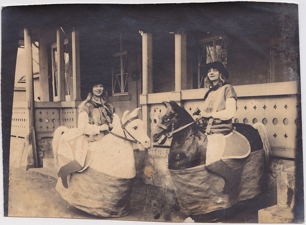 Two girls posing on little fake horsies vintage sepia photo