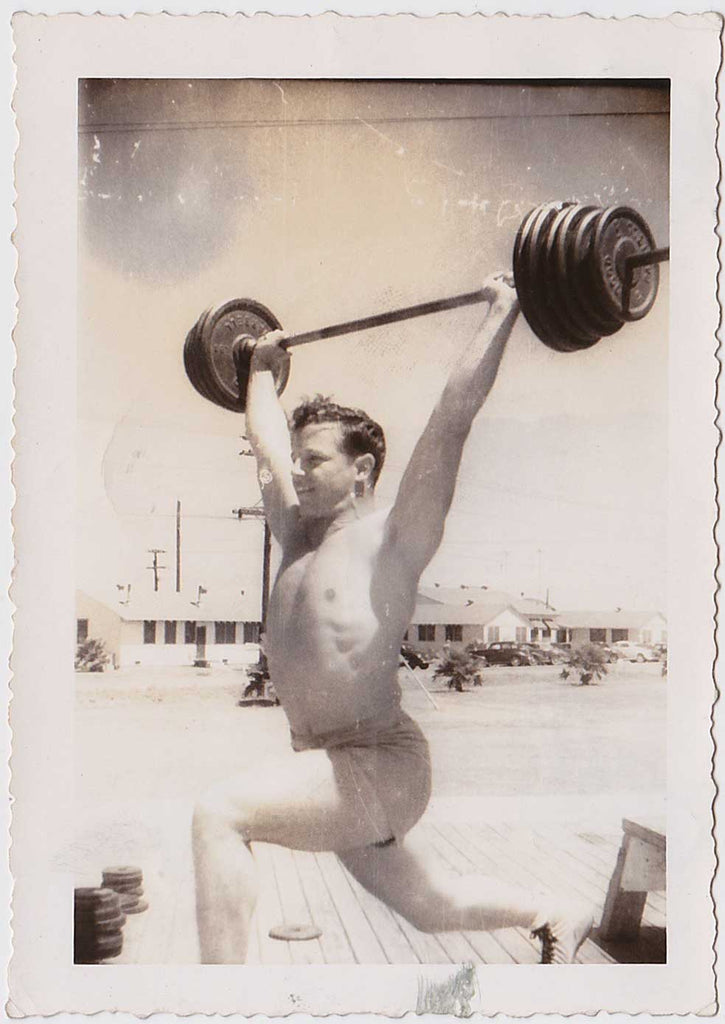 Handsome bodybuilder lifting weights outdoors vintage gay snapshot